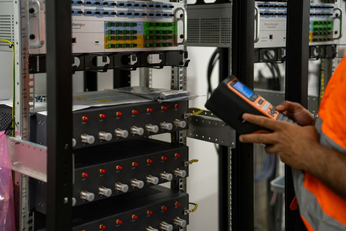 Technician testing network rack equipment during a maintenance visit